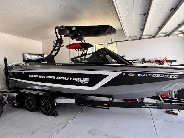 Slide: The Image of 2021 Nautique Super Air Nautique GS24 boat in garage, on trailer, side view. - 3