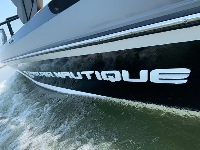 Slide: The Image of 2021 Nautique Super Air Nautique GS24 boat on water, close-up view of hull. - 30