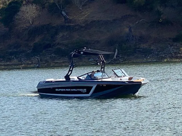 Slide: The Image of 2021 Nautique Super Air Nautique GS24 boat cruising on a lake. - 32