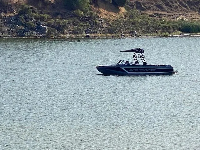 Slide: The Image of 2021 Nautique Super Air Nautique GS24 boat on a calm lake. - 33