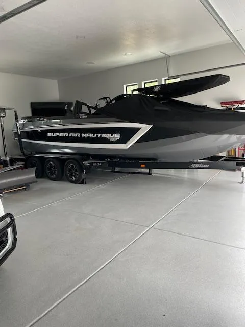 Slide: The Image of 2021 Nautique Super Air Nautique GS24 boat in a garage, black and gray exterior. - 34