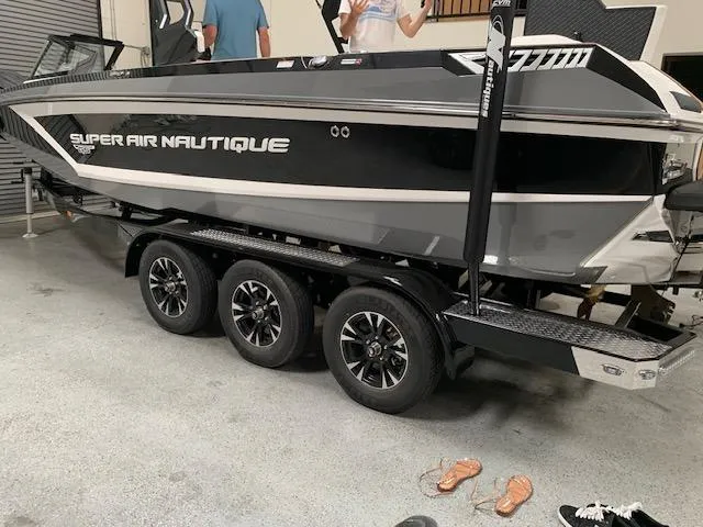 Slide: The Image of 2021 Nautique Super Air Nautique GS24 boat on a triple-axle trailer in a garage. - 4