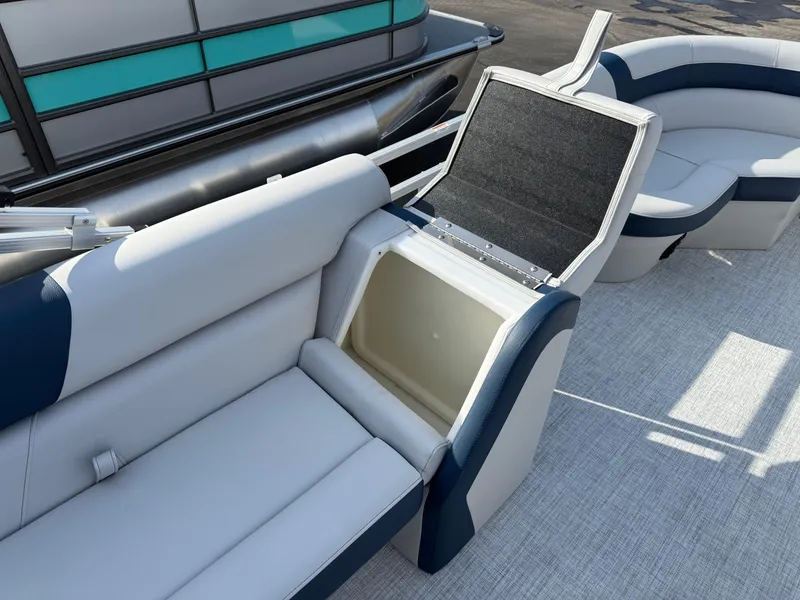 Slide: The Image of 2025 South Bay 20CR SE S pontoon boat with open storage compartment and cushioned seating. - 10
