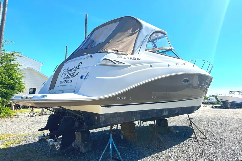 The Image of 2006 Larson Cabrio 350 boat on stands, sunny day, gravel lot. - 0