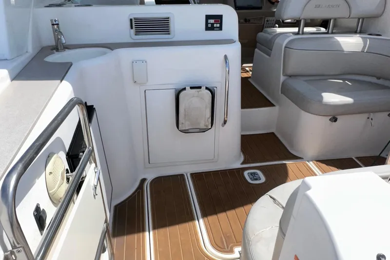 Slide: The Image of 2006 Larson Cabrio 350 boat interior with seating, sink, and wood flooring. - 18