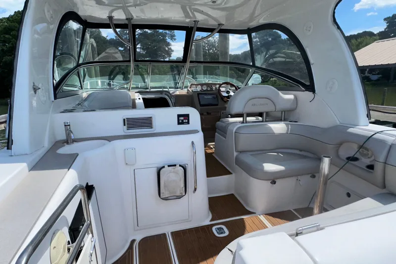 Slide: The Image of 2006 Larson Cabrio 350 boat interior with white seating and wood flooring. - 21
