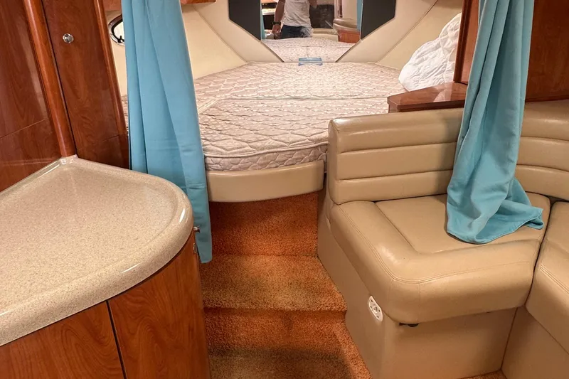 Slide: The Image of Interior of 2006 Larson Cabrio 350 boat with bed, seating, and blue curtains. - 24