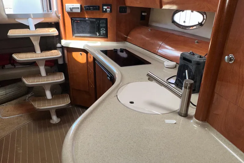 Slide: The Image of 2006 Larson Cabrio 350 yacht interior with modern kitchen and wooden cabinetry. - 28