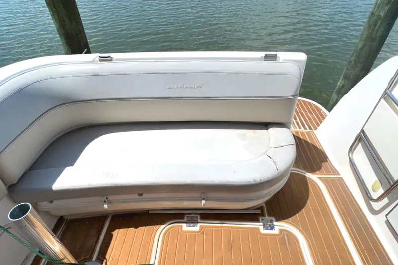 Slide: The Image of 2006 Larson Cabrio 350 boat with white seating and wooden deck, docked by water. - 33