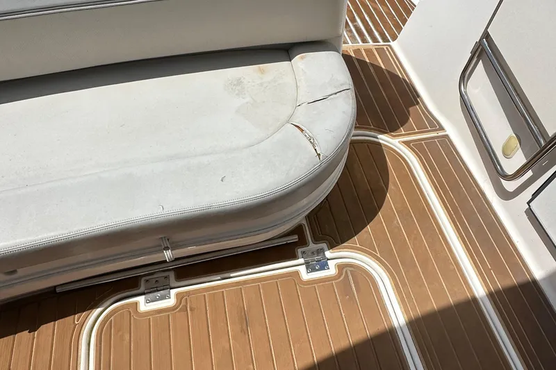 Slide: The Image of 2006 Larson Cabrio 350 boat interior with worn white seating and wooden flooring. - 37