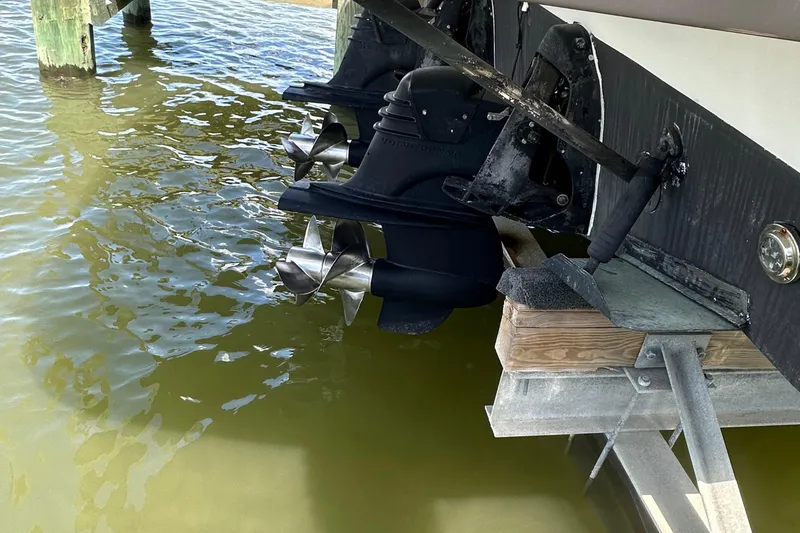 Slide: The Image of 2006 Larson Cabrio 350 boat propellers in water, docked on a lift. - 38