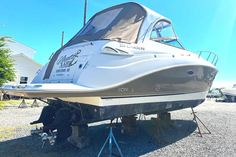 Slide: The Image of 2006 Larson Cabrio 350 boat on stands, outdoor setting, sunny day. - 4