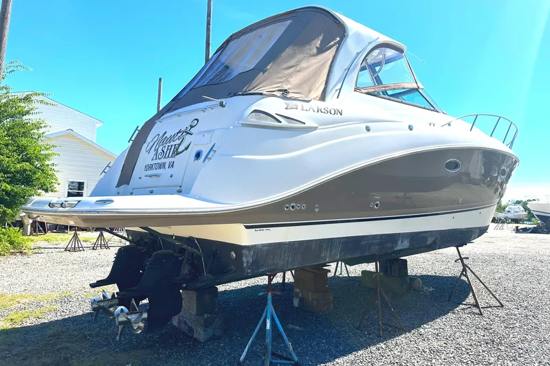 Slide: The Image of 2006 Larson Cabrio 350 boat on stands, outdoor setting, clear sky. - 5
