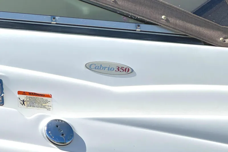 Slide: The Image of 2006 Larson Cabrio 350 boat exterior with logo and warning label. - 6