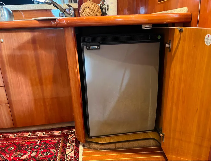 Slide: The Image of 2003 Cranchi 50 Mediterranne yacht kitchen with built-in fridge and wooden cabinetry. - 13