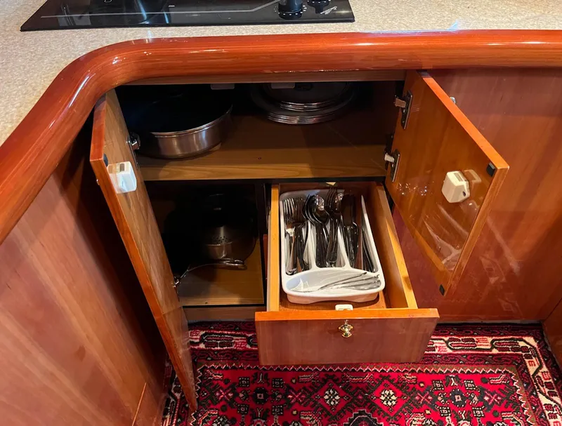 Slide: The Image of Kitchen storage in 2003 Cranchi 50 Mediterranne yacht with open cabinets and cutlery drawer. - 18
