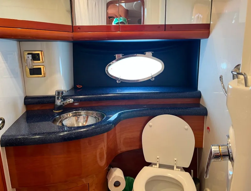 Slide: The Image of 2003 Cranchi 50 Mediterranne yacht bathroom with sink, toilet, and porthole window. - 19