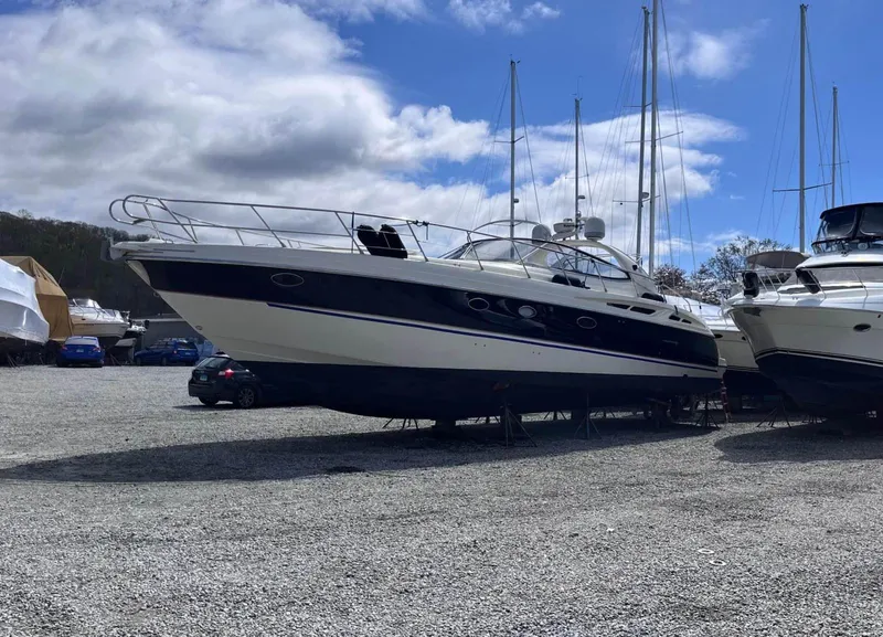 Slide: The Image of 2003 Cranchi 50 Mediterranne yacht on dry dock under a partly cloudy sky. - 2