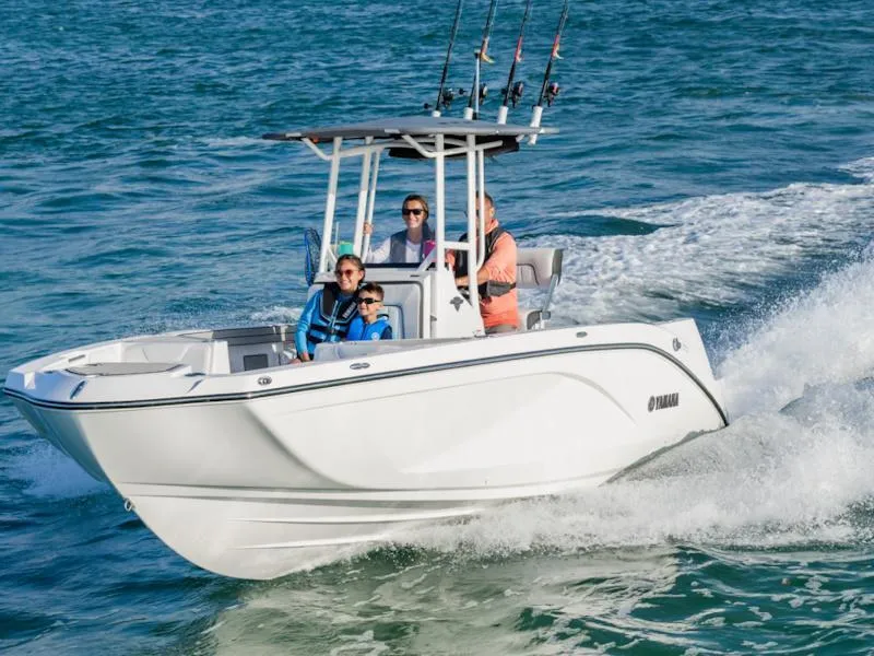 The Image of 2025 Yamaha Boats 220 FSH Sport cruising on open water with passengers. - 1