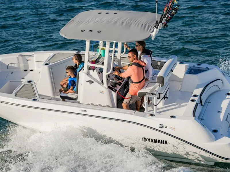 Slide: The Image of 2025 Yamaha Boats 220 FSH Sport cruising with passengers on a sunny day. - 9