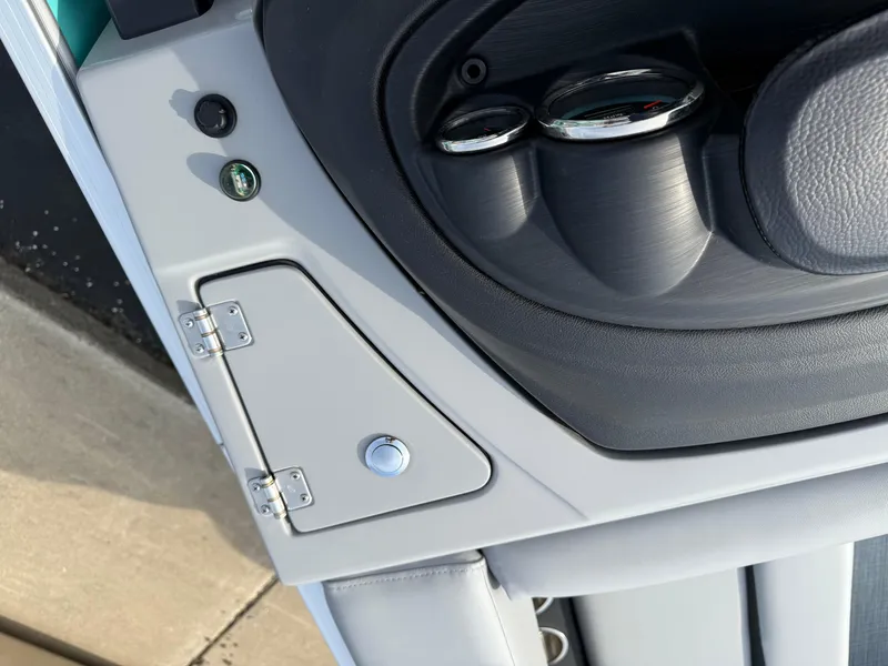 Slide: The Image of Interior detail of 2025 South Bay S222CR2 boat, featuring control panel and storage compartment. - 12