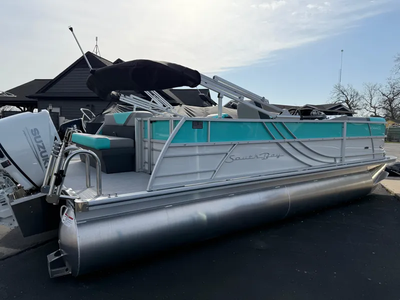 Slide: The Image of 2025 South Bay S222CR2 pontoon boat with teal accents and Suzuki outboard motor. - 25