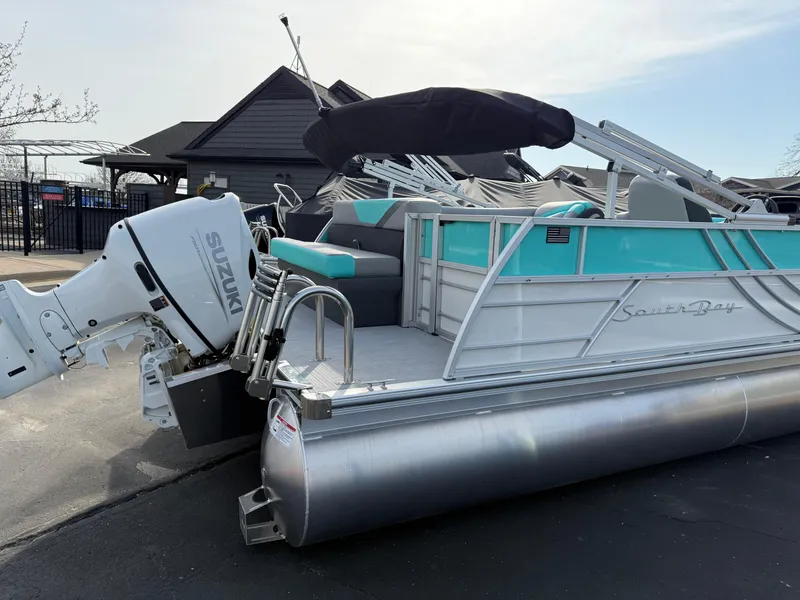 Slide: The Image of 2025 South Bay S222CR2 pontoon boat with Suzuki outboard motor, docked outdoors. - 26