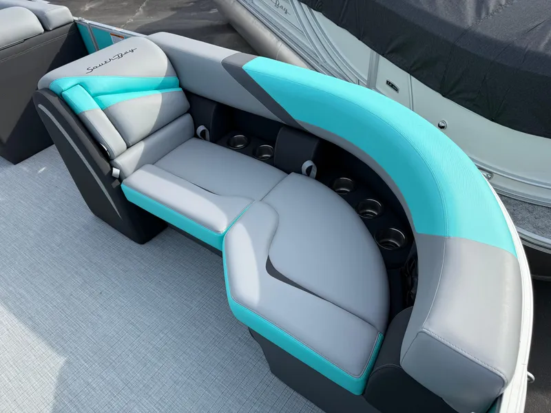 Slide: The Image of 2025 South Bay S222CR2 boat seating with teal and gray upholstery, featuring cup holders. - 3