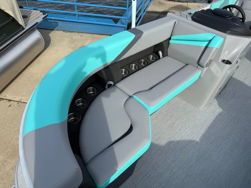 Slide: The Image of 2025 South Bay S222CR2 boat with teal and gray seating, featuring multiple cup holders. - 4