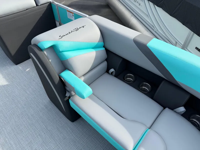 Slide: The Image of 2025 South Bay S222CR2 boat seat with teal and gray upholstery, featuring cup holders. - 5