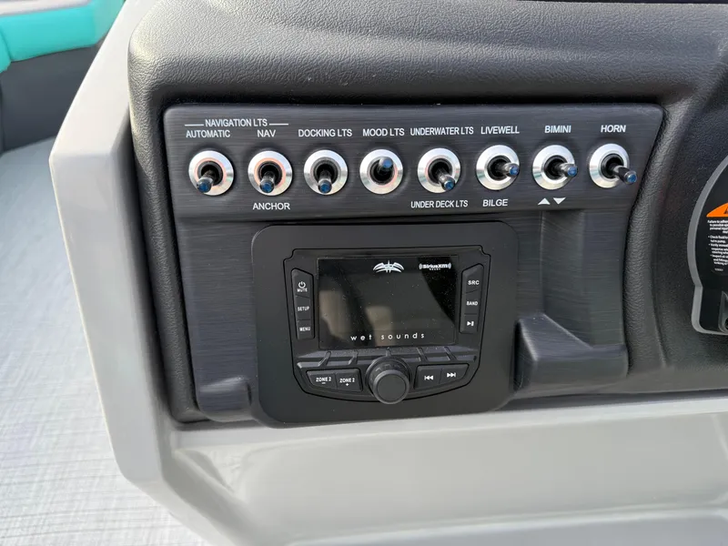 Slide: The Image of Control panel of 2025 South Bay S222CR2 boat with various switches and sound system. - 9