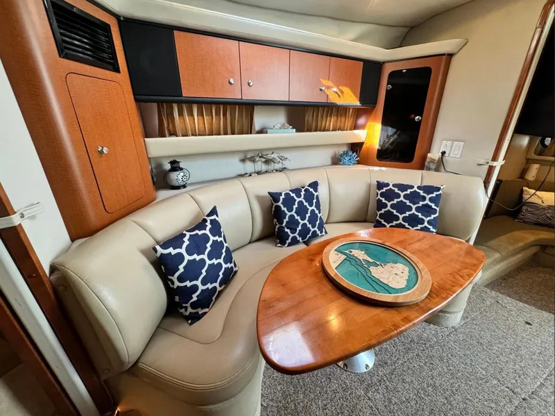 Slide: The Image of 2005 Chaparral Signature 350 interior with beige seating, wooden table, and decorative pillows. - 6