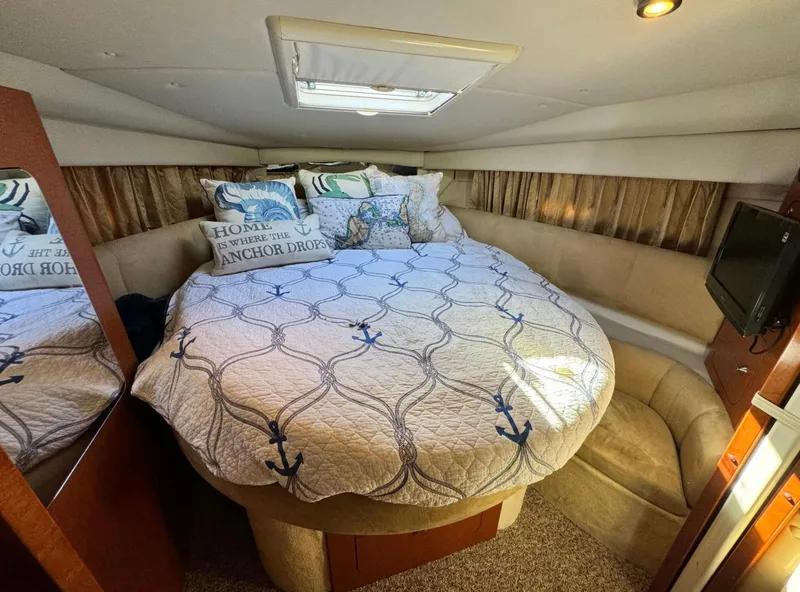 Slide: The Image of Cozy cabin interior of 2005 Chaparral Signature 350 with nautical-themed bedding and ambient lighting. - 8
