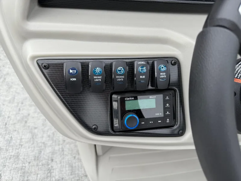 Slide: The Image of Control panel of 2025 South Bay 220RS LE boat with switches and audio system. - 10