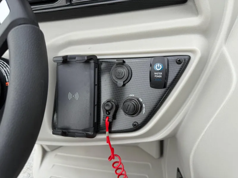 Slide: The Image of Control panel of 2025 South Bay 220RS LE boat with power button and phone holder. - 11