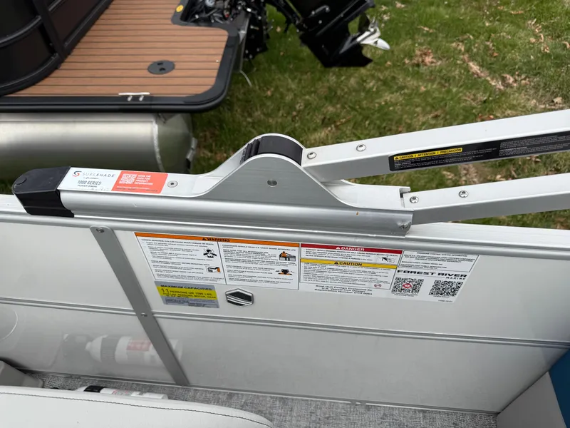 Slide: The Image of South Bay 220RS LE 2025 boat gate with safety labels and latch mechanism. - 13