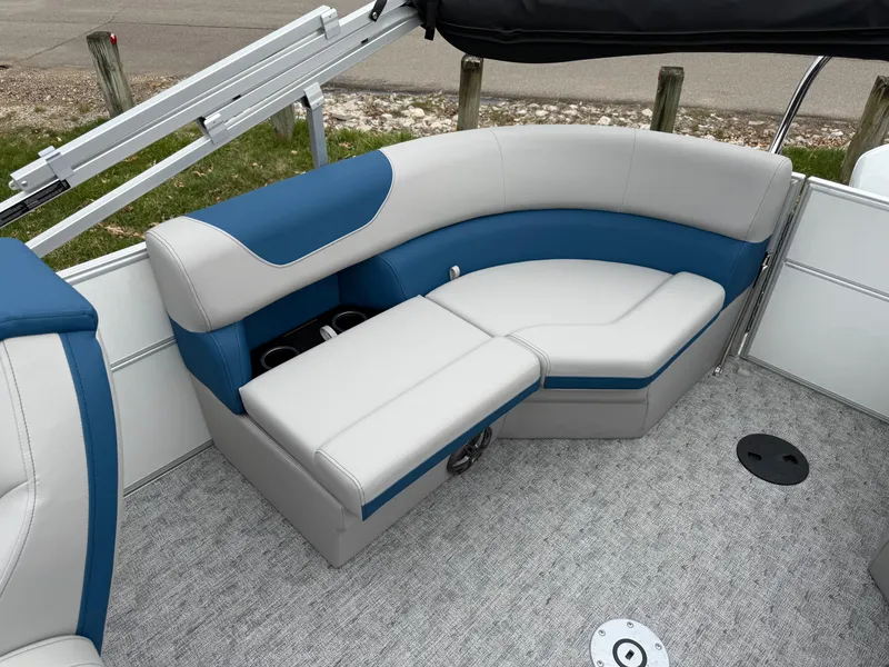 Slide: The Image of 2025 South Bay 220RS LE boat interior with blue and gray seating, cup holders, and carpeted floor. - 4