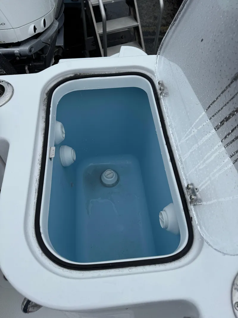 Slide: The Image of 2025 Wellcraft 263 Fisherman livewell with open lid, showcasing interior design. - 13