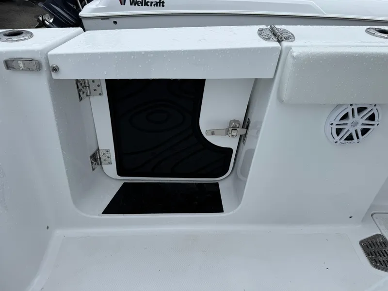 Slide: The Image of 2025 Wellcraft 263 Fisherman boat storage compartment with open hatch and speaker. - 14