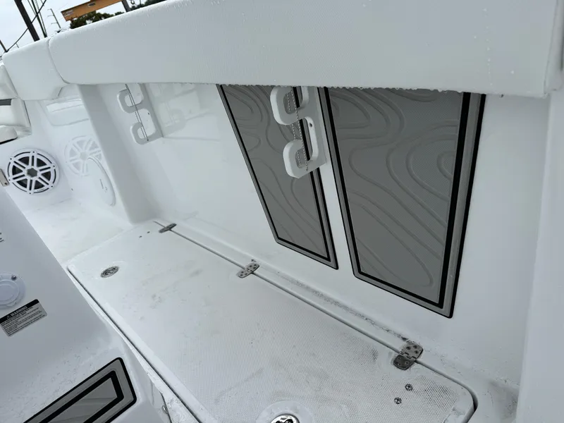 Slide: The Image of 2025 Wellcraft 263 Fisherman boat interior with storage compartments and speakers. - 25
