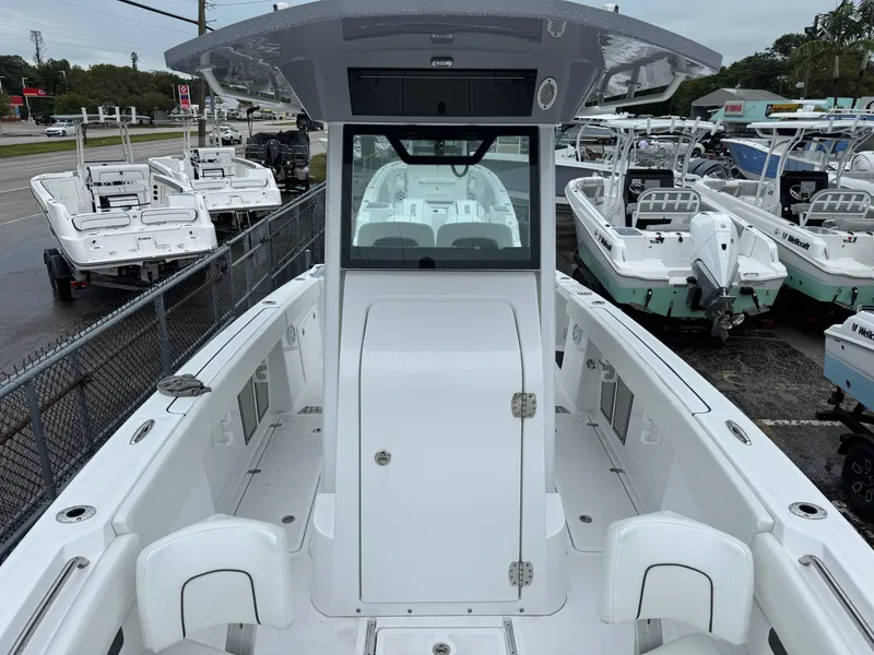 Slide: The Image of 2025 Wellcraft 263 Fisherman boat, white interior, docked among other boats at a marina. - 36