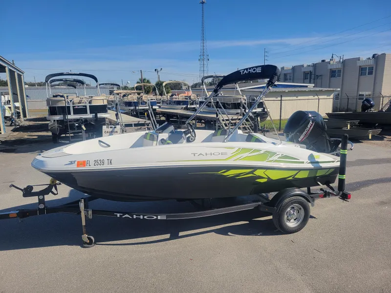 Slide: The Image of 2021 Tahoe T16 boat on trailer, parked outdoors, with vibrant green accents. - 1