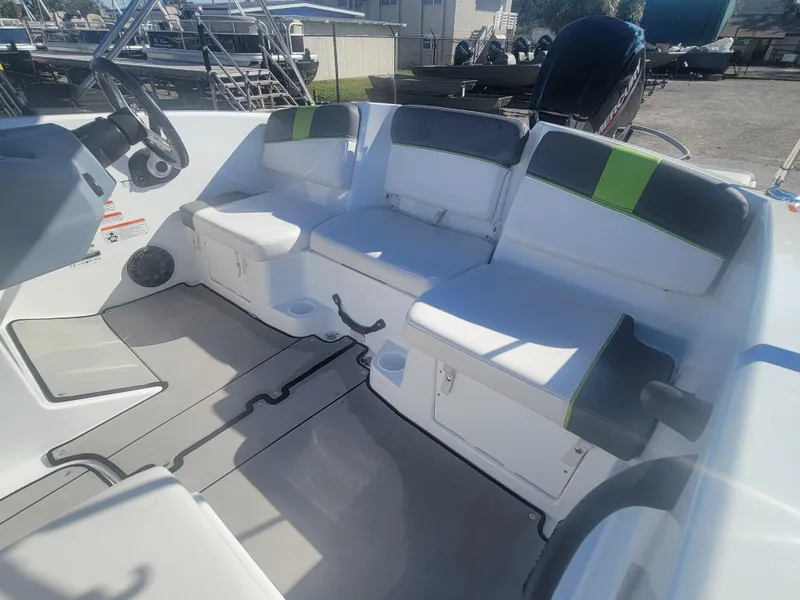 Slide: The Image of 2021 Tahoe T16 boat interior with white and green seating, steering wheel, and storage compartments. - 14
