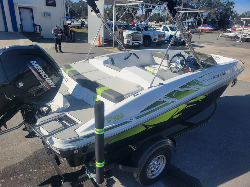 Slide: The Image of 2021 Tahoe T16 boat with Mercury engine, parked outdoors on a trailer. - 3
