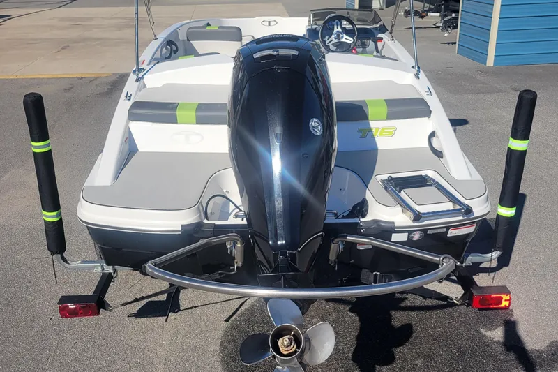 Slide: The Image of 2021 Tahoe T16 boat, rear view with outboard motor, parked on pavement. - 9