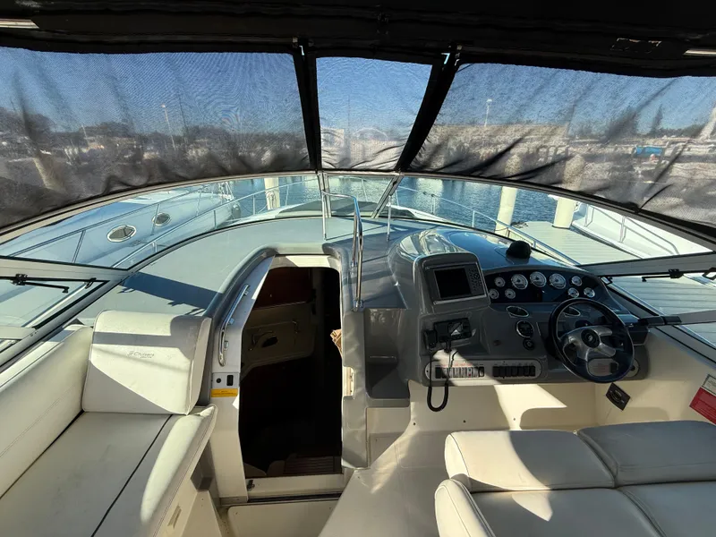 Slide: The Image of 2005 Cruisers Yachts 340 Express cockpit with helm, seating, and cabin entrance. - 12