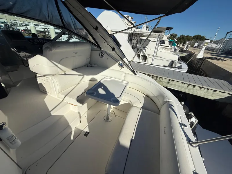 Slide: The Image of 2005 Cruisers Yachts 340 Express interior with white seating and table at marina. - 8