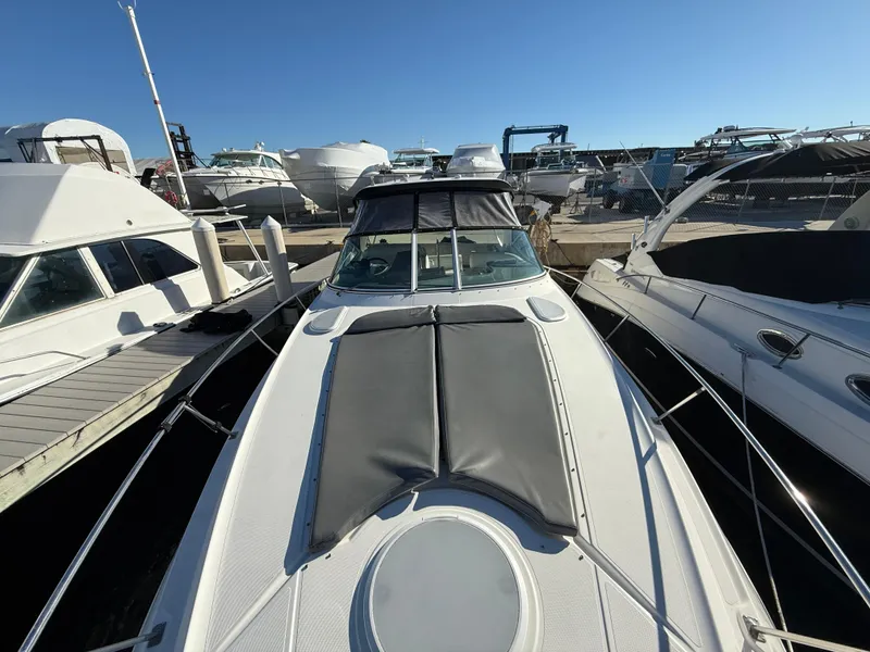 Slide: The Image of 2005 Cruisers Yachts 340 Express docked among other boats under clear blue sky. - 13