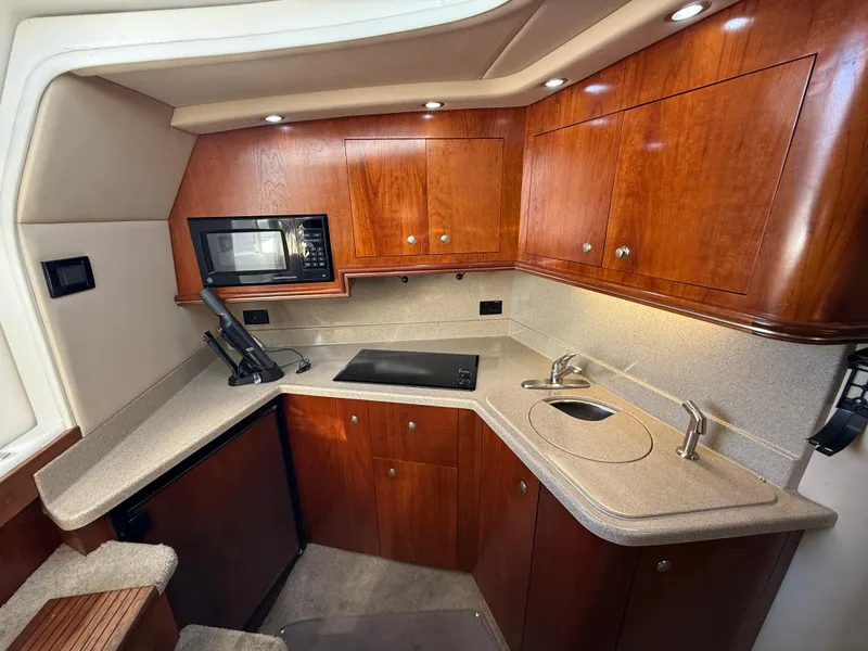 Slide: The Image of 2005 Cruisers Yachts 340 Express kitchen with wood cabinets and modern appliances. - 21