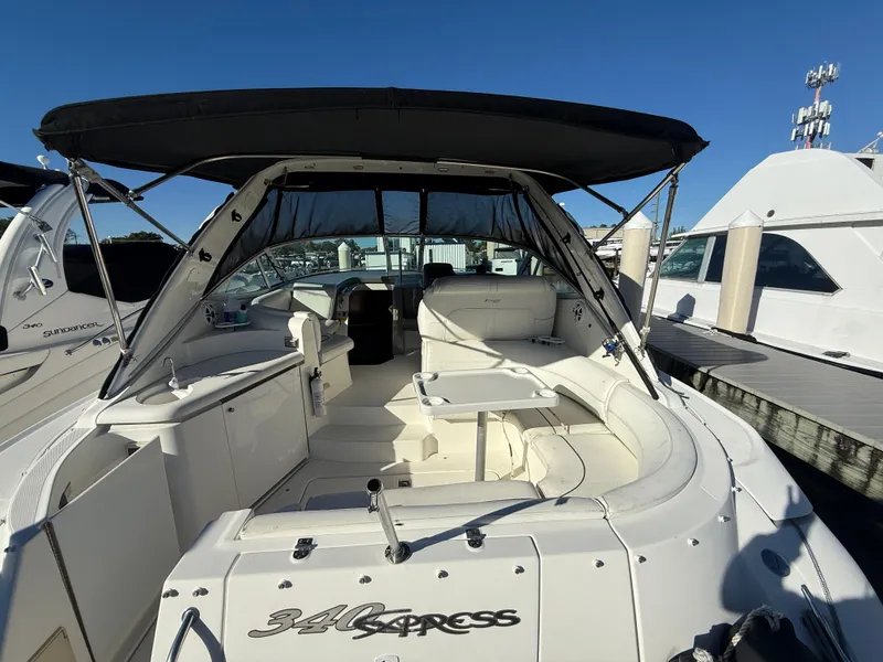 Slide: The Image of 2005 Cruisers Yachts 340 Express boat docked, featuring spacious seating and canopy. - 6